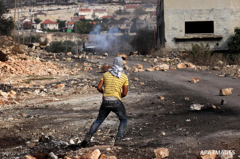 A Palestinian protester hurls stones towards Israeli security forces during clashes following a demonstration against the expropriation of Palestinian land by Israel on November 11, 2016 in the village of Kfar Qaddum, ne...