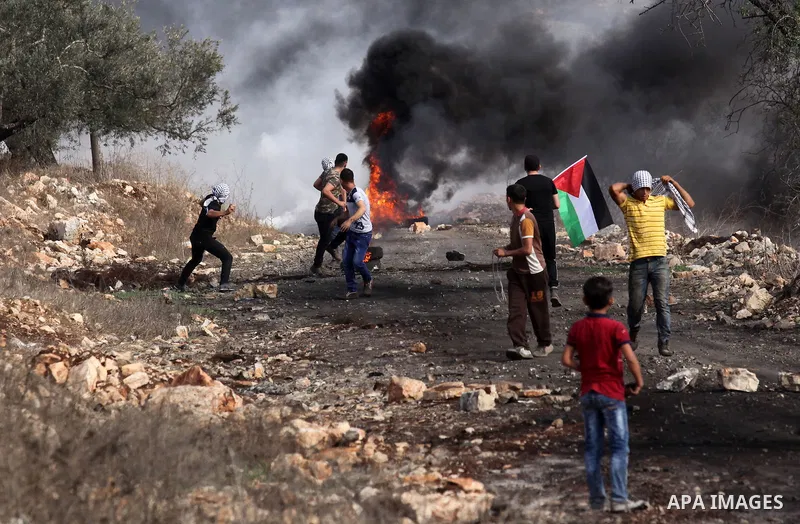 Palestinian protesters hurl stones towards Israeli security forces during clashes following a demonstration against the expropriation of Palestinian land by Israel on November 11, 2016 in the village of Kfar Qaddum, near...