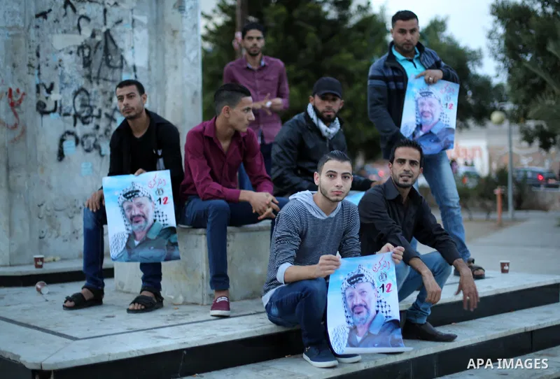 Palestinians hold posters of the late Palestinian leader Yasser Arafat to mark the 12 anniversary of his death in Gaza city on Nov. 11, 2016. Photo by Mohammed Asad
