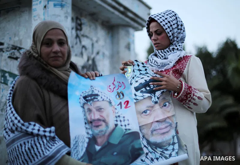 Palestinians hold posters of the late Palestinian leader Yasser Arafat to mark the 12 anniversary of his death in Gaza city on Nov. 11, 2016. Photo by Mohammed Asad