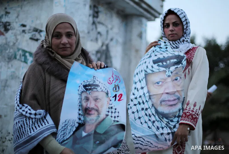 Palestinians hold posters of the late Palestinian leader Yasser Arafat to mark the 12 anniversary of his death in Gaza city on Nov. 11, 2016. Photo by Mohammed Asad