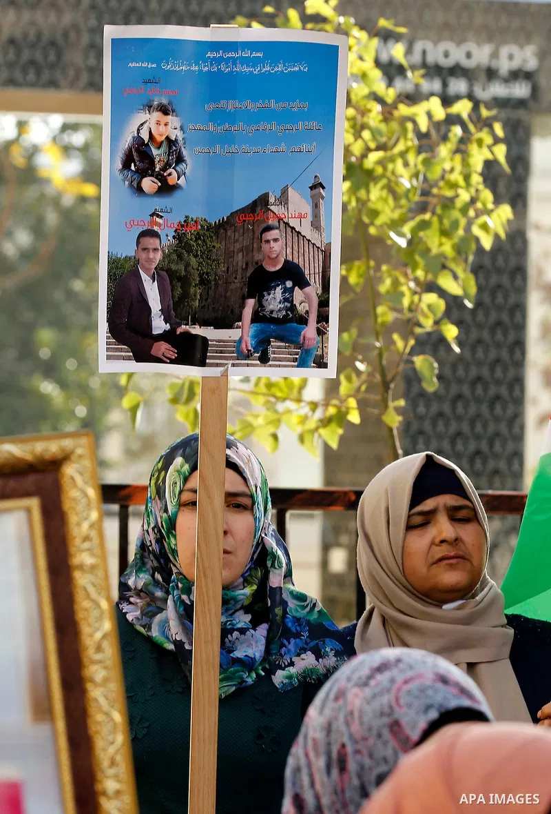 Palestinians hold banners during a protest demanding Israel return the bodies of Palestinians who allegedly stabbed Israelis, in the West Bank city of Hebron, on Nov. 13, 2016. Photo by Wisam Hashlamoun