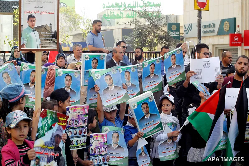 Palestinians hold banners during a protest demanding Israel return the bodies of Palestinians who allegedly stabbed Israelis, in the West Bank city of Hebron, on Nov. 13, 2016. Photo by Wisam Hashlamoun
