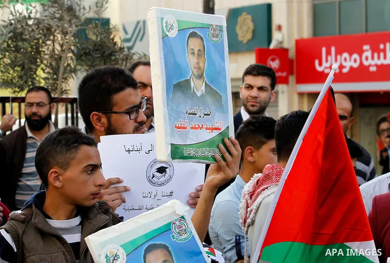 Palestinians hold banners during a protest demanding Israel return the bodies of Palestinians who allegedly stabbed Israelis, in the West Bank city of Hebron, on Nov. 13, 2016. Photo by Wisam Hashlamoun