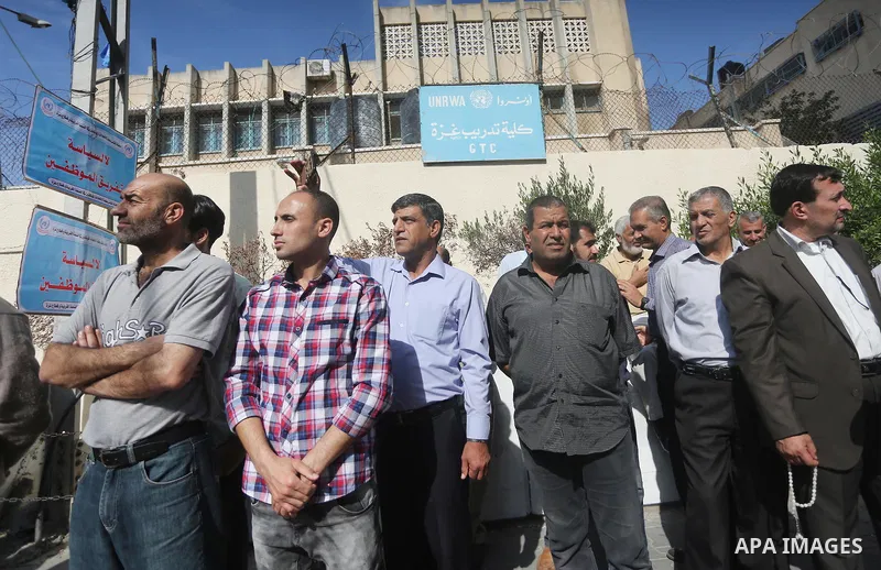 Palestinians hold banners during a protest against the UNRWA decision to reduce of the aid in front of the headquarters United Nations Relief and Works Agency (UNRWA), in Gaza city, on Nov. 14, 2016. Photo by Mohammed As...