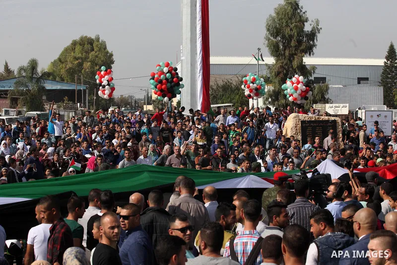 Palestinians watch the raising of a Palestinian flag during a rally marking the Palestinian Declaration of Independence in 1988, in the West Bank city of Tulkarm November 14, 2016. Photo by Nedal Eshtayah