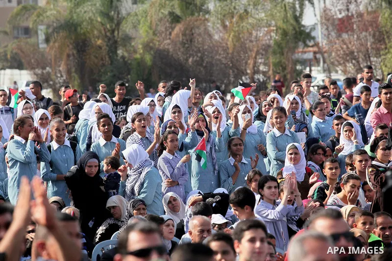 Palestinians watch the raising of a Palestinian flag during a rally marking the Palestinian Declaration of Independence in 1988, in the West Bank city of Tulkarm November 14, 2016. Photo by Nedal Eshtayah