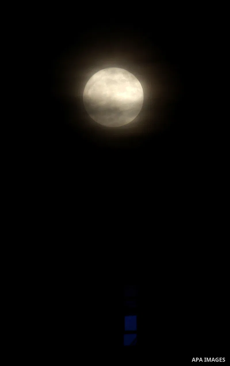 The moon is partly covered by clouds as it rises over the West Bank city of Nablus on November 14, 2016. The moon will be the closest to Earth since 1948 at a distance of 356,509 kilometres (221,524 miles), creating what...