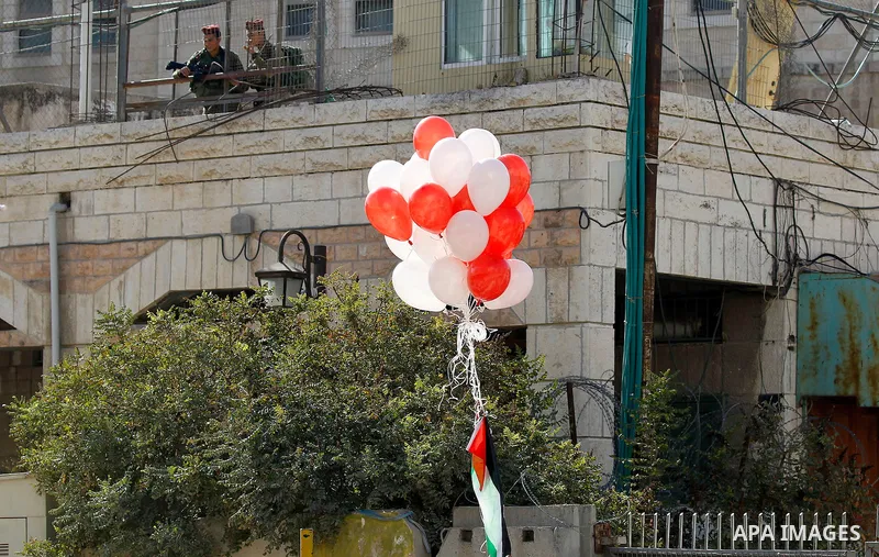Israeli soldiers watch Palestinians (unseen) taking part in a march marking the Palestinian national day of independence, in the West Bank city of Hebron on November 15, 2016. Photo by Wisam Hashlamoun