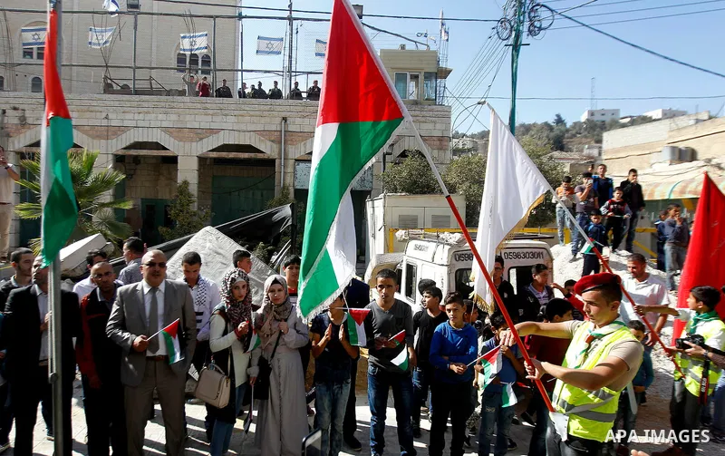 Palestinian scouts take part in a march marking the Palestinian national day of independence, in the West Bank city of Hebron on November 15, 2016. Photo by Wisam Hashlamoun