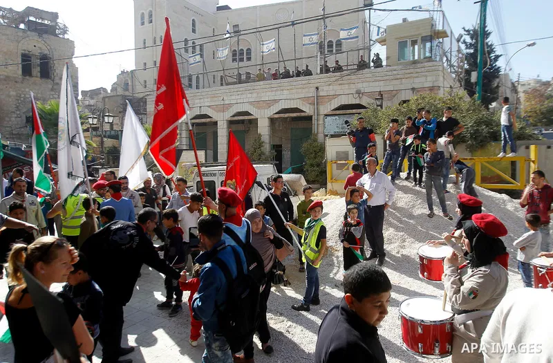 Palestinian scouts take part in a march marking the Palestinian national day of independence, in the West Bank city of Hebron on November 15, 2016. Photo by Wisam Hashlamoun