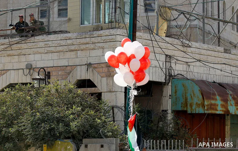 Israeli soldiers watch Palestinians (unseen) taking part in a march marking the Palestinian national day of independence, in the West Bank city of Hebron on November 15, 2016. Photo by Wisam Hashlamoun