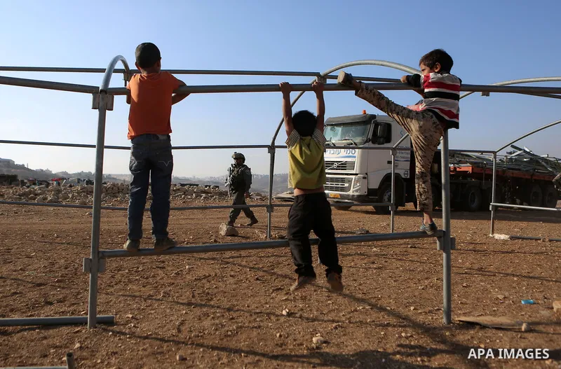 Palestinian Bedouin children play as Israeli security forces confiscate barracks in the Bedouin residential area after Israeli authorities said it was built without a permit in the West Bank village of Jab'a, north east...