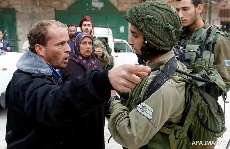 A Palestinian man scuffles with Israeli security forces after arrested two Palestinian youths, charges throw stones towards Israeli soldiers, in the West Bank city of Hebron, on Nov. 16, 2016. Photo by Wisam Hashlamoun