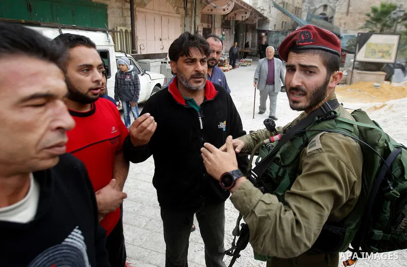A Palestinian man scuffles with Israeli security forces after arrested two Palestinian youths, charges throw stones towards Israeli soldiers, in the West Bank city of Hebron, on Nov. 16, 2016. Photo by Wisam Hashlamoun