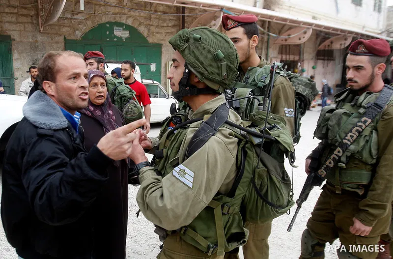 A Palestinian man scuffles with Israeli security forces after arrested two Palestinian youths, charges throw stones towards Israeli soldiers, in the West Bank city of Hebron, on Nov. 16, 2016. Photo by Wisam Hashlamoun