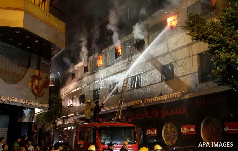 Egyptians gather as Civil defense firefighters effort to control a fire that broke out in a store in the Fagala district of Cairo on November 16, 2016. Photo by Amr Sayed