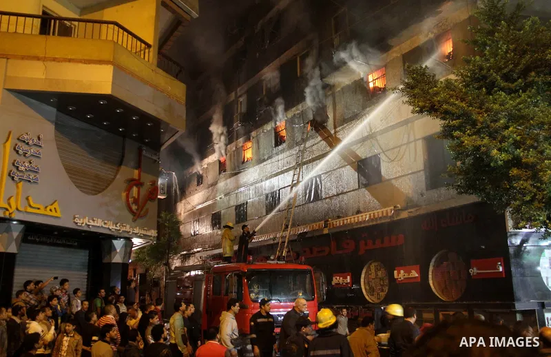 Egyptians gather as Civil defense firefighters effort to control a fire that broke out in a store in the Fagala district of Cairo on November 16, 2016. Photo by Amr Sayed