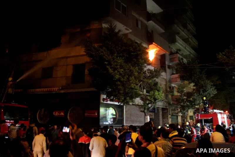Egyptians gather as Civil defense firefighters effort to control a fire that broke out in a store in the Fagala district of Cairo on November 16, 2016. Photo by Amr Sayed
