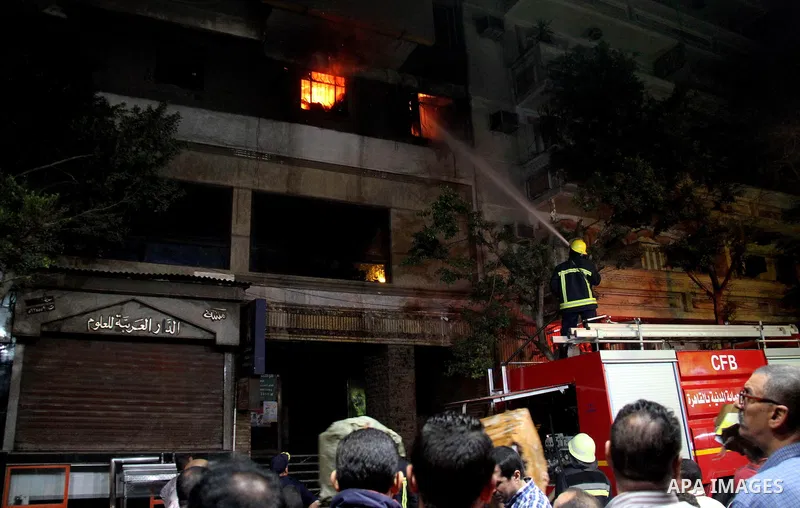 Egyptians gather as Civil defense firefighters effort to control a fire that broke out in a store in the Fagala district of Cairo on November 16, 2016. Photo by Amr Sayed