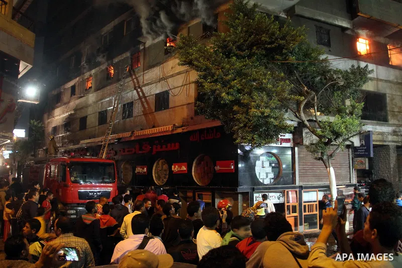 Egyptians gather as Civil defense firefighters effort to control a fire that broke out in a store in the Fagala district of Cairo on November 16, 2016. Photo by Amr Sayed