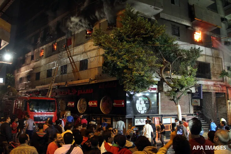 Egyptians gather as Civil defense firefighters effort to control a fire that broke out in a store in the Fagala district of Cairo on November 16, 2016. Photo by Amr Sayed