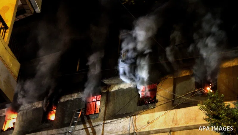 Egyptians gather as Civil defense firefighters effort to control a fire that broke out in a store in the Fagala district of Cairo on November 16, 2016. Photo by Amr Sayed