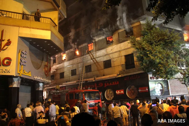 Egyptians gather as Civil defense firefighters effort to control a fire that broke out in a store in the Fagala district of Cairo on November 16, 2016. Photo by Amr Sayed