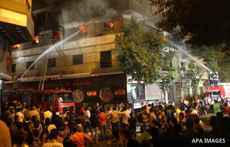 Egyptians gather as Civil defense firefighters effort to control a fire that broke out in a store in the Fagala district of Cairo on November 16, 2016. Photo by Amr Sayed