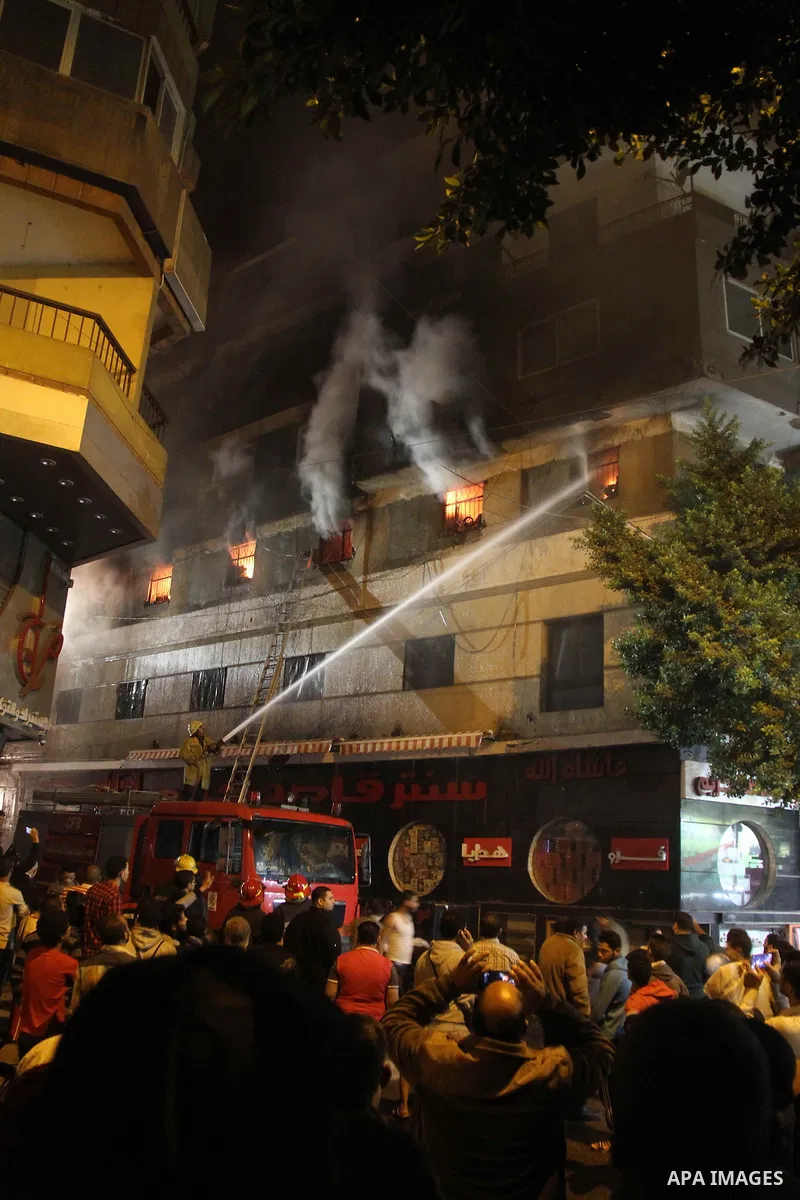 Egyptians gather as Civil defense firefighters effort to control a fire that broke out in a store in the Fagala district of Cairo on November 16, 2016. Photo by Amr Sayed