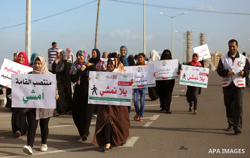 Palestinian women march on a street, calling for the rehabilitation of marginalised women in Gaza City on November 17, 2016. Photo by Yasser Qudih