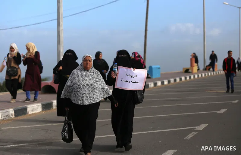Palestinian women march on a street, calling for the rehabilitation of marginalised women in Gaza City on November 17, 2016. Photo by Yasser Qudih