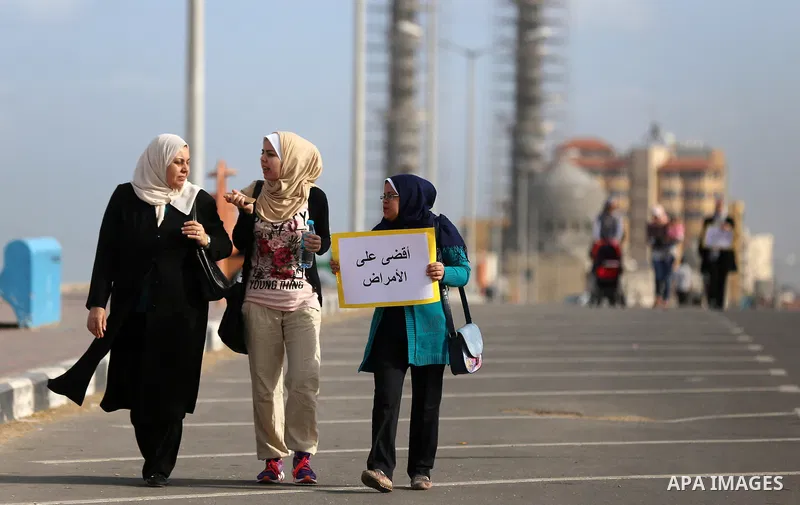 Palestinian women march on a street, calling for the rehabilitation of marginalised women in Gaza City on November 17, 2016. Photo by Yasser Qudih