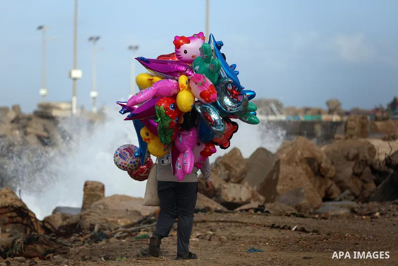 A Palestinian man sells Balloons at the Gaza seaport, on November 17, 2016. Photo by Yasser Qudih