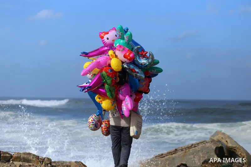 A Palestinian man sells Balloons at the Gaza seaport, on November 17, 2016. Photo by Yasser Qudih