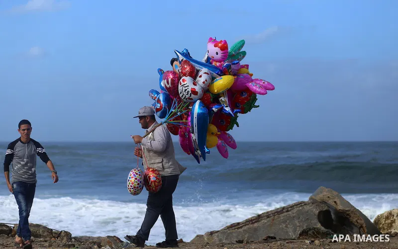 A Palestinian man sells Balloons at the Gaza seaport, on November 17, 2016. Photo by Yasser Qudih
