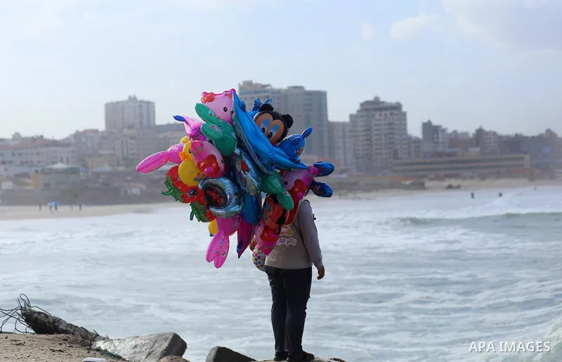 A Palestinian man sells Balloons at the Gaza seaport, on November 17, 2016. Photo by Yasser Qudih
