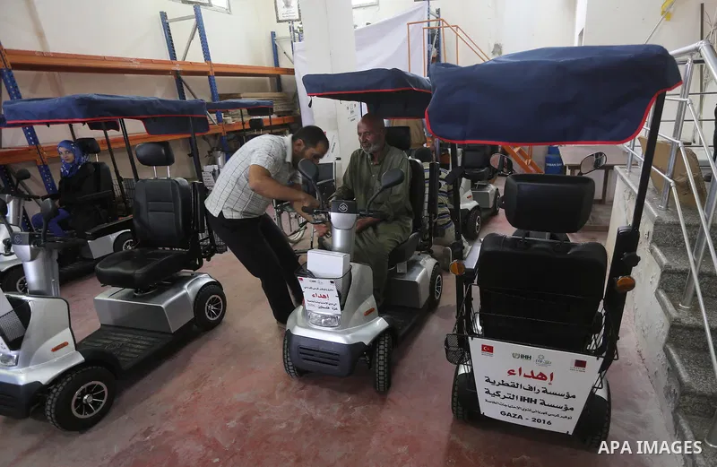 Palestinians with special needs receive electric cars financed by the Turkish humanitarian relief and freedoms IHH and Qatari Foundation Ruff, in Gaza City, on November 17, 2016. Photo by Mohammed Asad