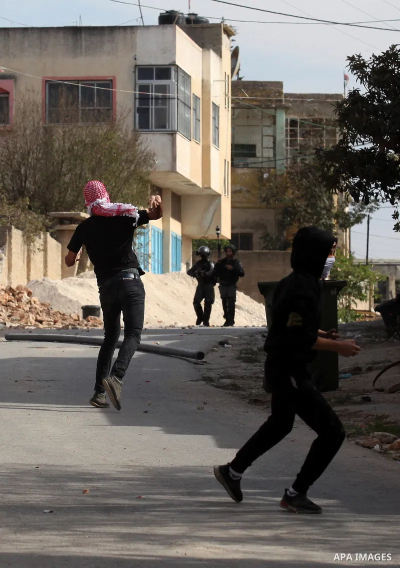 Palestinian protesters throw stones towards Israeli security forces during clashes following a demonstration against the expropriation of Palestinian land by Israel on November 18, 2016 in the village of Kfar Qaddum, nea...