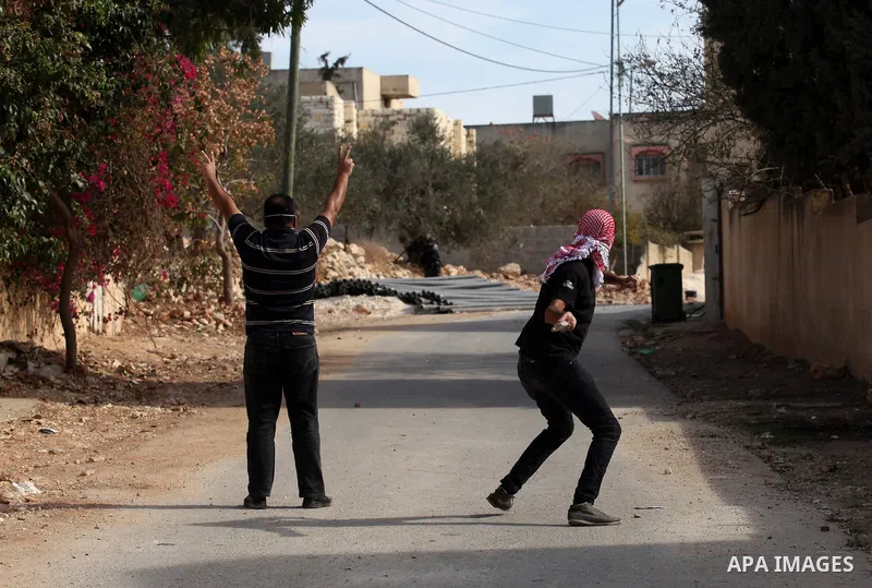 A Palestinian protester throws stones towards Israeli security forces during clashes following a demonstration against the expropriation of Palestinian land by Israel on November 18, 2016 in the village of Kfar Qaddum, n...