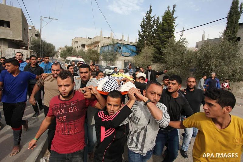 Mourners carry the body of Mohammed Abu Saada, a 26-year-old Palestinian man who was reportedly killed in clashes with the Israeli army along the Gaza border, during his funeral in the Nuseirat refugee camp in the centra...