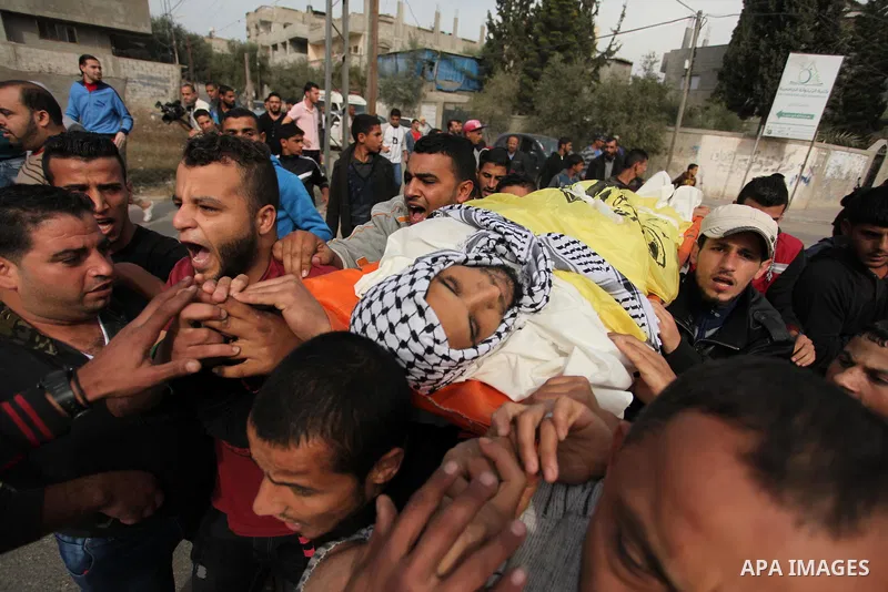 Mourners carry the body of Mohammed Abu Saada, a 26-year-old Palestinian man who was reportedly killed in clashes with the Israeli army along the Gaza border, during his funeral in the Nuseirat refugee camp in the centra...