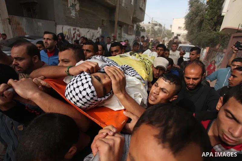 Mourners carry the body of Mohammed Abu Saada, a 26-year-old Palestinian man who was reportedly killed in clashes with the Israeli army along the Gaza border, during his funeral in the Nuseirat refugee camp in the centra...