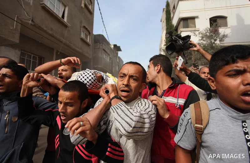 Mourners carry the body of Mohammed Abu Saada, a 26-year-old Palestinian man who was reportedly killed in clashes with the Israeli army along the Gaza border, during his funeral in the Nuseirat refugee camp in the centra...