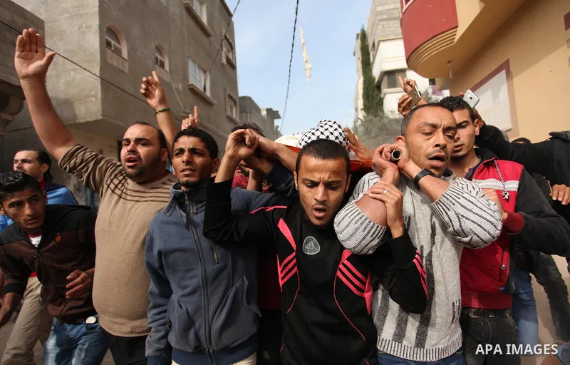 Mourners carry the body of Mohammed Abu Saada, a 26-year-old Palestinian man who was reportedly killed in clashes with the Israeli army along the Gaza border, during his funeral in the Nuseirat refugee camp in the centra...