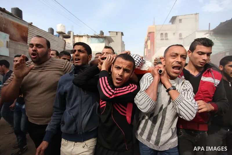Mourners carry the body of Mohammed Abu Saada, a 26-year-old Palestinian man who was reportedly killed in clashes with the Israeli army along the Gaza border, during his funeral in the Nuseirat refugee camp in the centra...