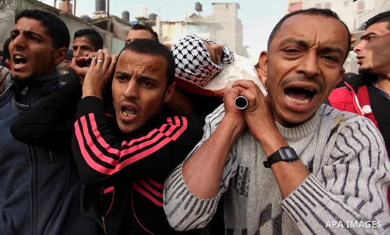 Mourners carry the body of Mohammed Abu Saada, a 26-year-old Palestinian man who was reportedly killed in clashes with the Israeli army along the Gaza border, during his funeral in the Nuseirat refugee camp in the centra...