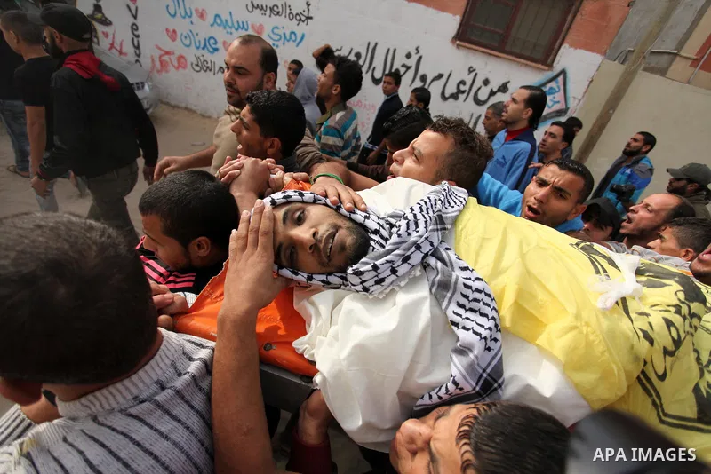 Mourners carry the body of Mohammed Abu Saada, a 26-year-old Palestinian man who was reportedly killed in clashes with the Israeli army along the Gaza border, during his funeral in the Nuseirat refugee camp in the centra...