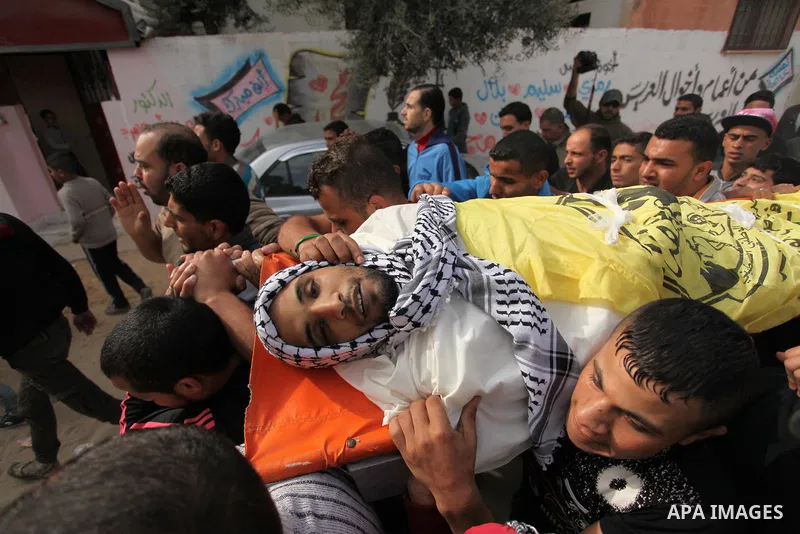 Mourners carry the body of Mohammed Abu Saada, a 26-year-old Palestinian man who was reportedly killed in clashes with the Israeli army along the Gaza border, during his funeral in the Nuseirat refugee camp in the centra...