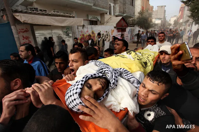 Mourners carry the body of Mohammed Abu Saada, a 26-year-old Palestinian man who was reportedly killed in clashes with the Israeli army along the Gaza border, during his funeral in the Nuseirat refugee camp in the centra...